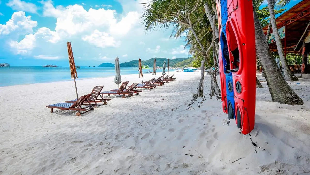 Ghế nằm và dù trên bãi cát, xuồng kayak bên cạnh