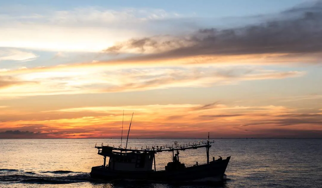 Sunset behind a fishing boat